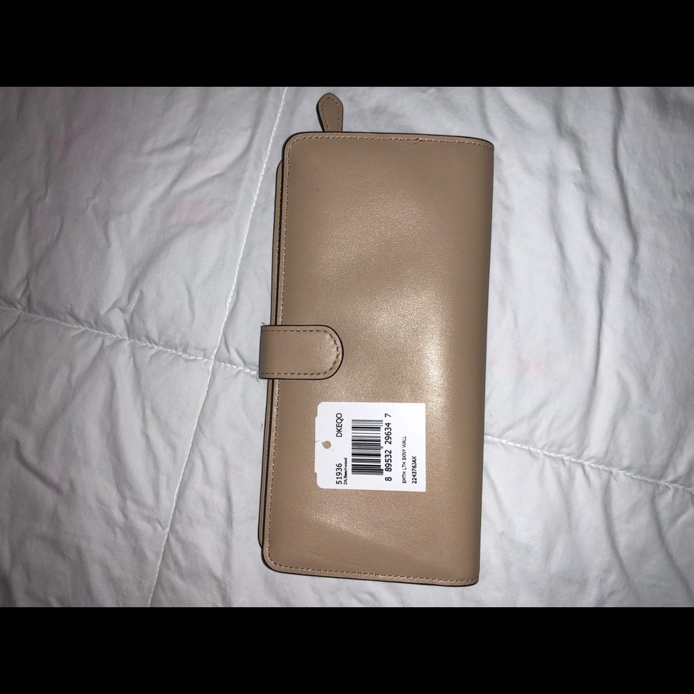 Light tan Coach leather checkbook wallet.